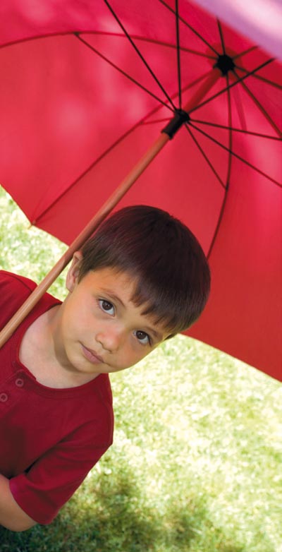 Ni&ntilde;o con paraguas rojo